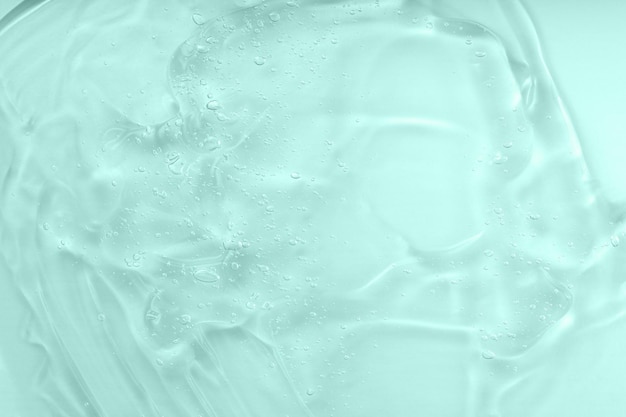 Texture de gel cosmétique avec fond de bulles Échantillon de sérum clair d'acide hyaluronique Tache d'huile verte liquide Le concept de cosmétique naturelle Produit hydratant pour la peau