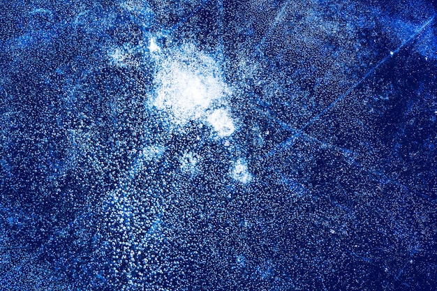 Texture de glace avec des bulles congelées et des fissures sur fond bleu foncé. Beau fond décoratif abstrait. Conception abstraite élégante pour les emballages, les cadeaux, les tissus, les textiles, l'ameublement. Modèle d'hiver.