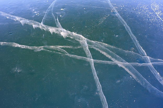 la texture de la glace fissure le baïkal, le fond abstrait de la glace d'hiver bleu transparent