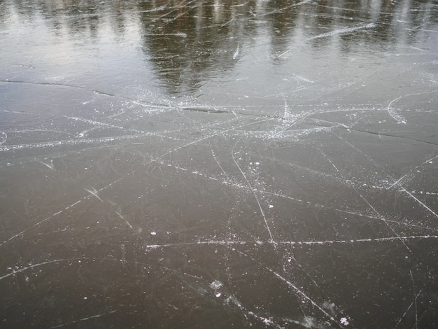 Texture de glace gelée sur le lac avec des traces de patins