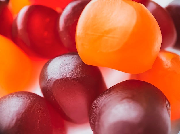 Texture en gros plan de bonbons gélifiés multivitaminés rouges, oranges et violets. Concept de mode de vie sain.