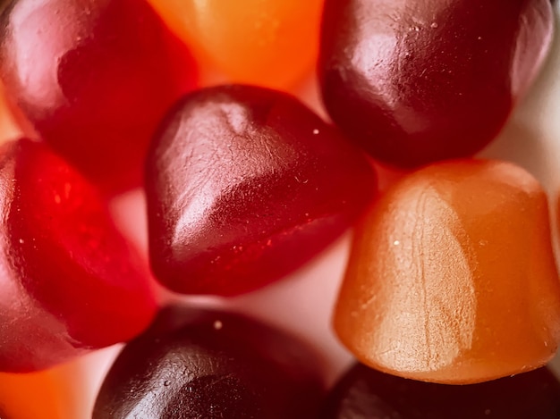 Texture en gros plan de bonbons gélifiés multivitaminés rouges, oranges et violets. Concept de mode de vie sain.