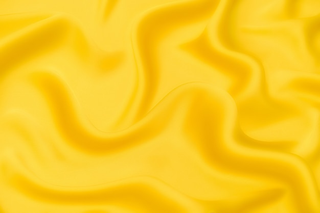 Texture en gros plan de tissu ou de tissu orange ou jaune naturel de la même couleur. Texture de tissu de coton naturel, de soie ou de laine, ou de matière textile en lin. Fond de toile jaune.