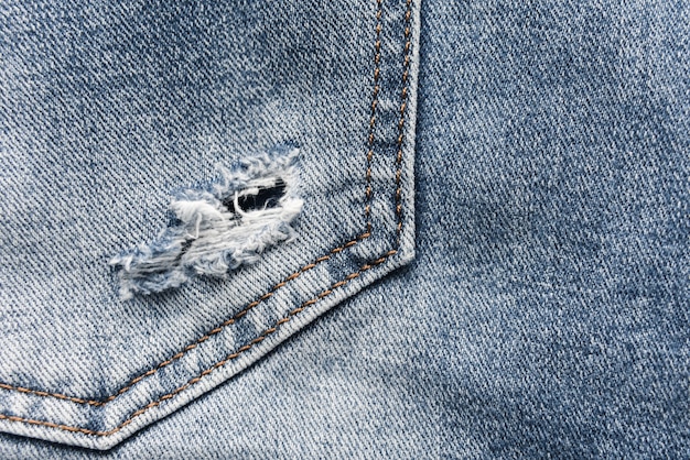 Texture de jean bleu denim avec éraflures et trous