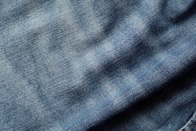 La texture d'un jean bleu avec des vagues et des ombres formant