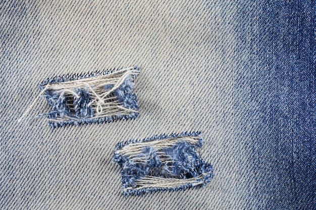 Texture de jeans en denim déchiré bleu.