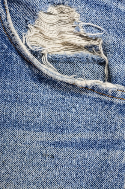 Texture de jeans en denim déchiré bleu.