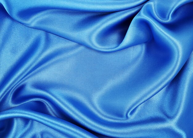 Texture lisse et élégante de soie bleue ou de tissu de luxe satiné comme arrière-plan abstrait