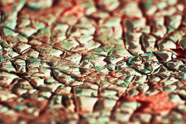 Texture macro de peinture fissurée sur la surface Fond vintage dans des couleurs rouges et turquoises à la mode texture détaillée