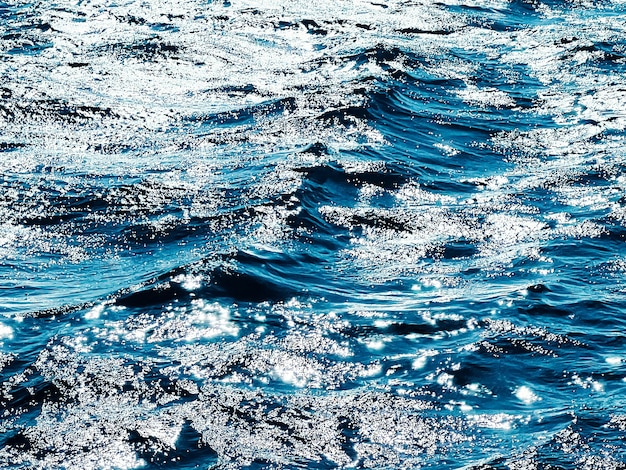 La texture de la mer et le concept de nature côtière l'eau de l'océan bleu comme fond de surface qui coule des vagues et des somm...