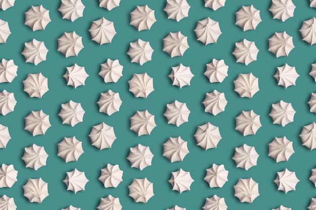 Texture de modèle sans couture avec des biscuits à la meringue française sur fond vert