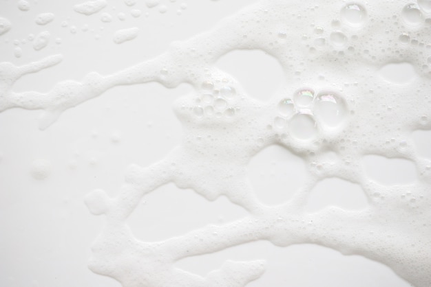 Photo texture de mousse savonneuse abstrait blanc. shampoing mousse à bulles