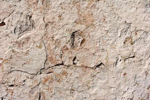 Texture d'un mur en béton avec des fissures et des rayures qui peuvent être utilisées comme arrière-plan