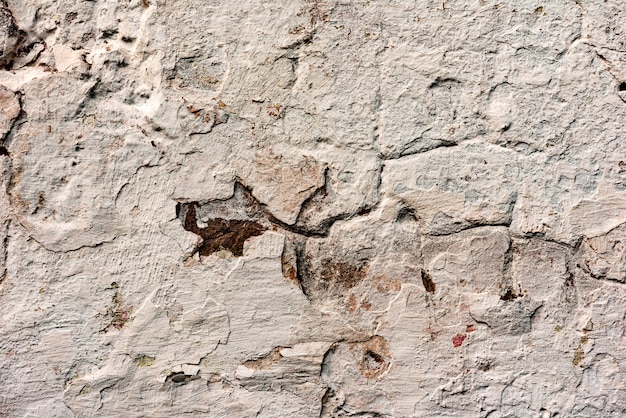 Texture d'un mur en béton avec des fissures et des rayures qui peuvent être utilisées comme arrière-plan