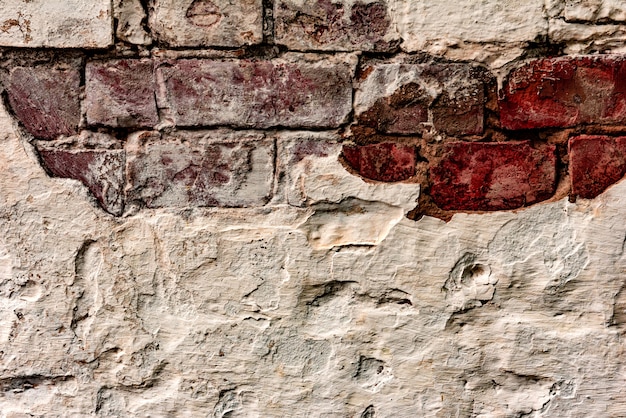 Texture d'un mur en béton avec des fissures et des rayures qui peuvent être utilisées comme arrière-plan