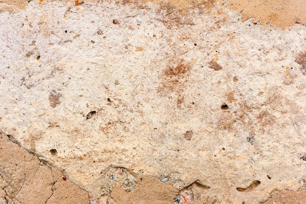 Texture d'un mur de béton avec des fissures et des rayures qui peuvent être utilisées comme arrière-plan