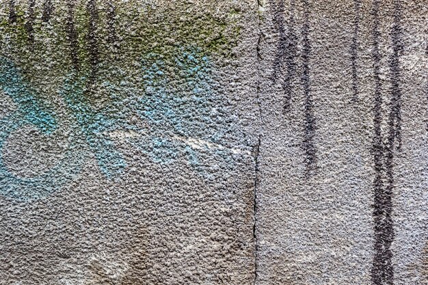 Texture de mur en béton avec des taches de peinture bleue et des stries sales