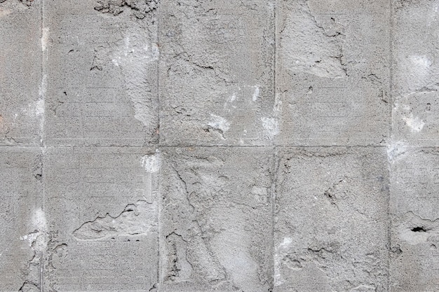 Texture d'un mur en béton avec des traces de carreaux de parement démantelés