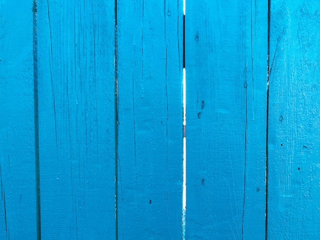 La texture d'un mur en bois a résisté à une clôture faite de vieilles planches bleues