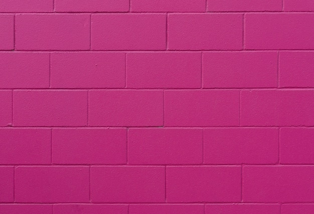 Texture de mur de brique peinte rose et