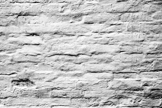 Texture d'un mur de briques avec des fissures et des rayures qui peuvent être utilisées comme arrière-plan