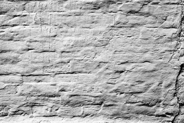 Texture d'un mur de briques avec des fissures et des rayures qui peuvent être utilisées comme arrière-plan