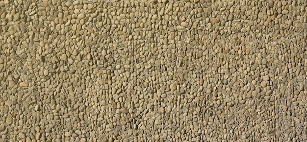 Texture d'un mur de pierre avec de petites pierres de cailloux rondes partie d'un Mur de pierre comme fond ou