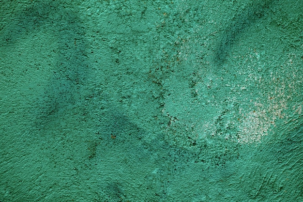 Texture de mur vert forêt fissurée grunge avec peinture décolorée et surface de ciment rugueux dans une vue plein cadre.