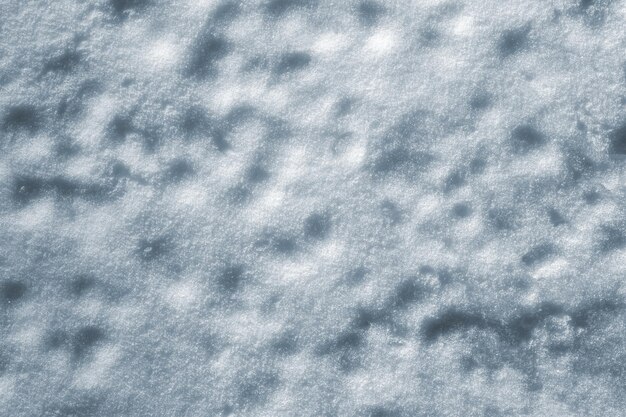 La texture naturelle de la surface de neige inégale comme arrière-plan pour la conception