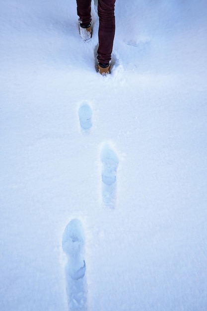 Texture de la neige avec des empreintes de pas à l'heure d'hiver