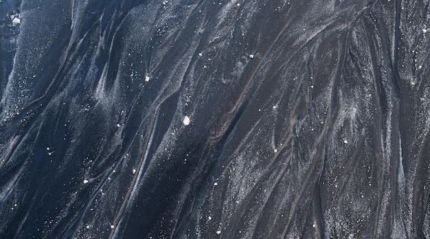 Texture noire des dunes de sable du bord de mer de la plage, mise à plat.