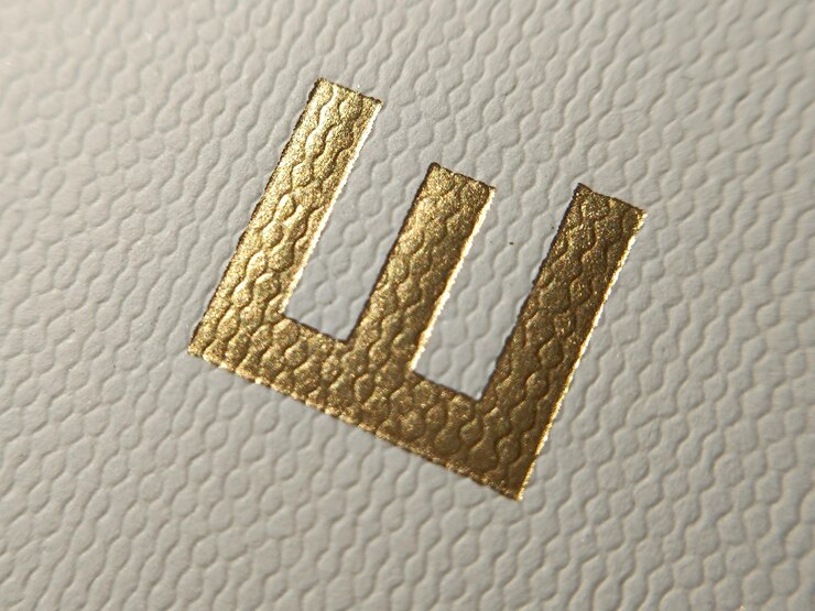 Photo texture de papier avec l'alphabet en or en relief