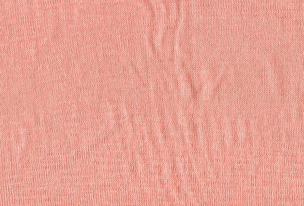 Texture d'un papier peint pull rose tricoté. Matière textile rose avec motif en osier.