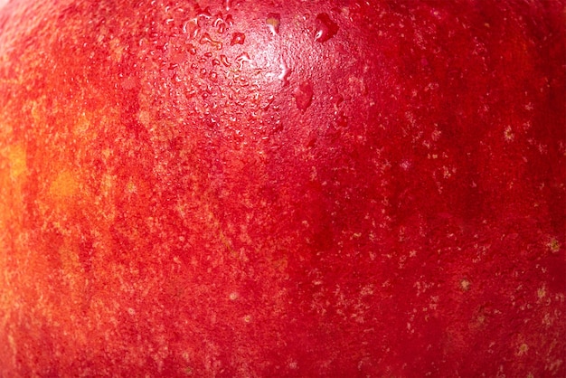 Photo la texture d'une pomme est rouge avec une peau de pomme jaune avec des gouttes d'eau