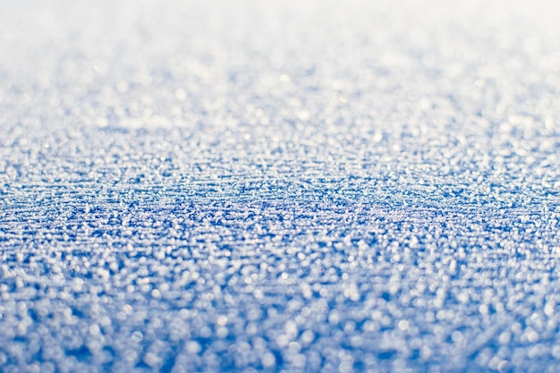 Texture de première glace froide pétillante. Toile de fond enneigée bleue. Fond d'hiver pour la conception. L'abstraction dans la nature.