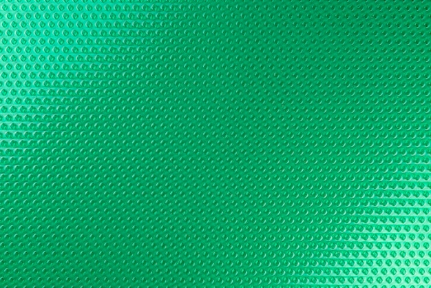 Photo texture réelle faite de rhombus en caoutchouc vert en gros plan éclairé par la lumière