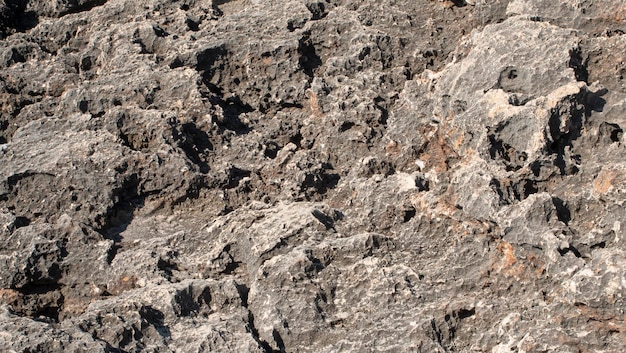 Texture des roches noires érodées par l'eau de mer