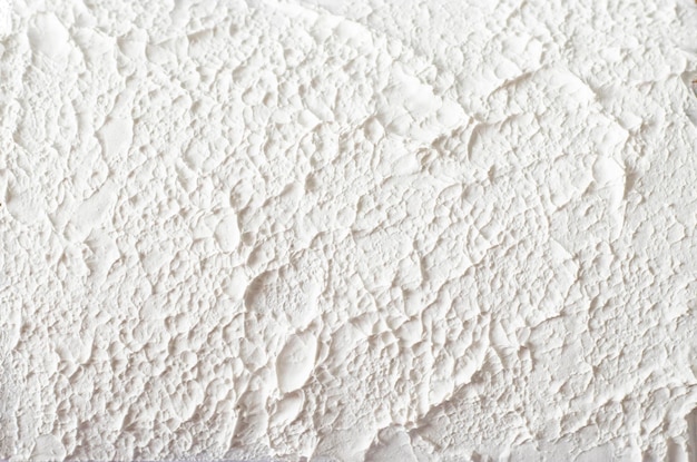 Texture rugueuse de mastic blanc sur un mur