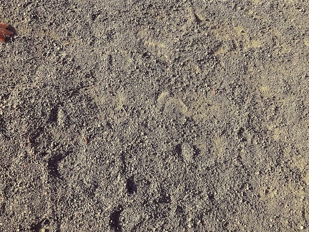 Texture de sable de terre sèche grise avec de gros cailloux L'arrière-plan