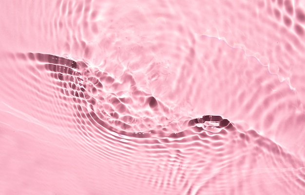 Texture de surface de l'eau claire de couleur rose liquide avec des bulles d'éclaboussures