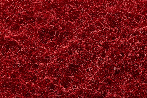 La texture de la surface des fils rouges entrelacés de fibres synthétiques abrasives.