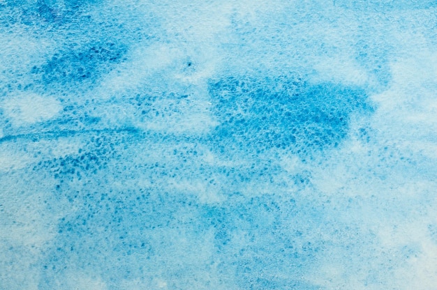 Texture de taches d'aquarelle bleue sur papier blanc