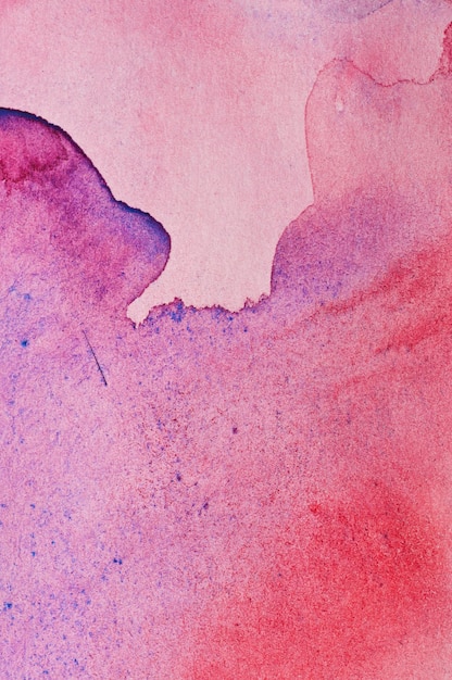 Texture des taches d'aquarelle rouges et violettes sur papier blanc