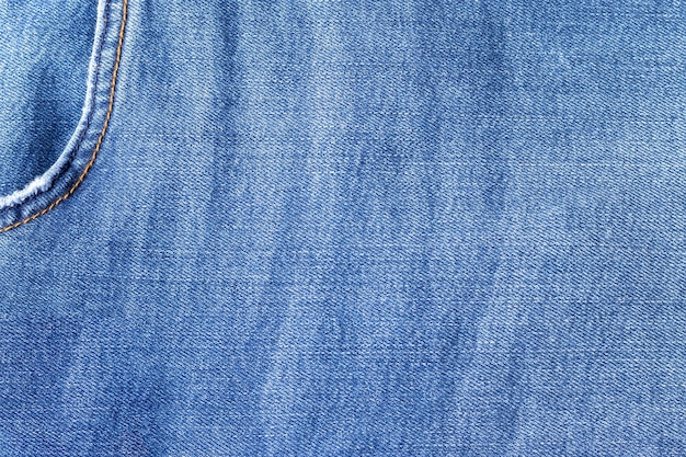 Texture de tissu de jeans bleu vif. Fond denim avec poche dans le coin