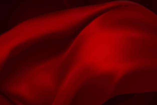 La texture de tissu de luxe en soie rouge ou en satin peut être utilisée comme arrière-plan abstrait abstrait tissu de luxe ou vague liquide ou plis ondulés