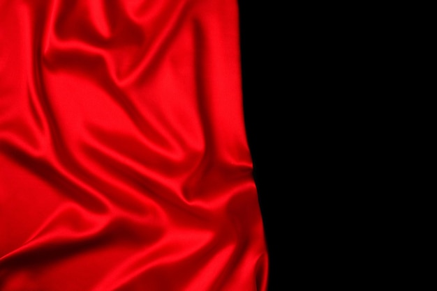 La texture de tissu de luxe en soie rouge ou en satin peut être utilisée comme arrière-plan abstrait. Vue de dessus.
