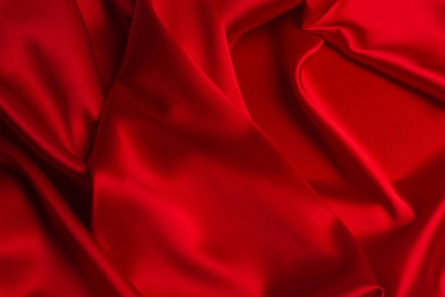 La texture de tissu de luxe en soie rouge ou en satin peut être utilisée comme fond abstrait.