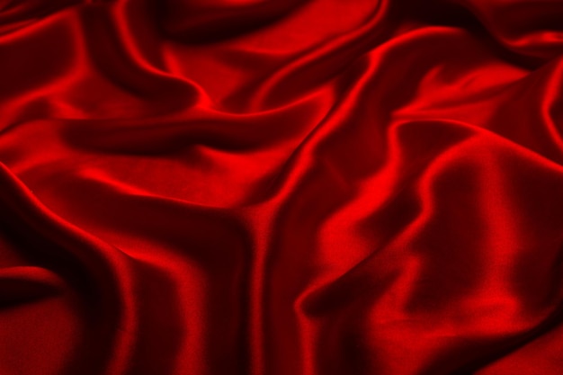 La texture de tissu de luxe en soie rouge ou en satin peut être utilisée comme fond abstrait