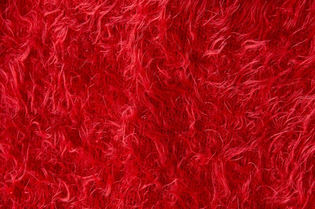 Texture de tissu moelleux rouge. Gros plan du pull en peluche bordeaux. Fond de Noël