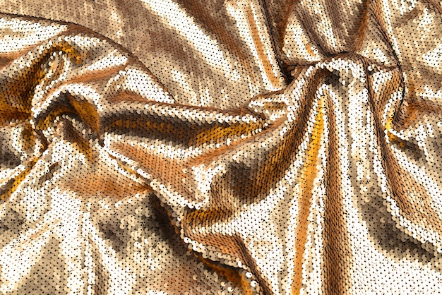 Texture de tissu paillettes dorées.